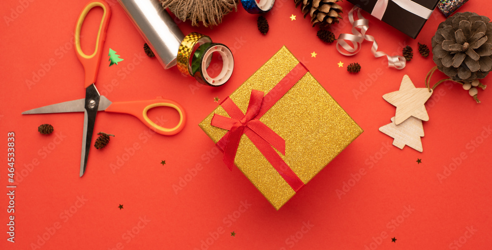 Gift box with a ribbon in a Christmas gift warping composition. Bright red background. Gift box with a ribbon in a Christmas gift warping composition. Bright red background.