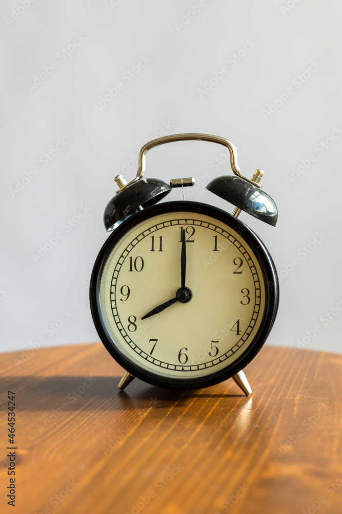 black alarm clock on a wooden table black alarm clock on a wooden table