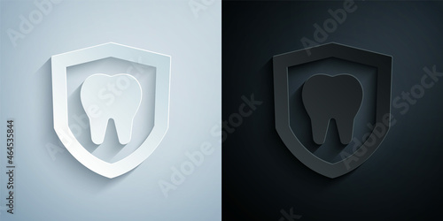 Paper cut Dental protection icon isolated on grey and black background. Tooth on shield logo. Paper art style. Vector