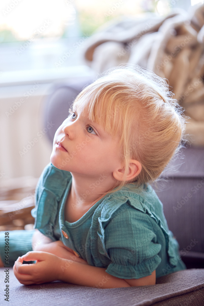 Smiling Young Girl Sitting On Sofa In Lounge At Home Watching TV Smiling Young Girl Sitting On Sofa In Lounge At Home Watching TV