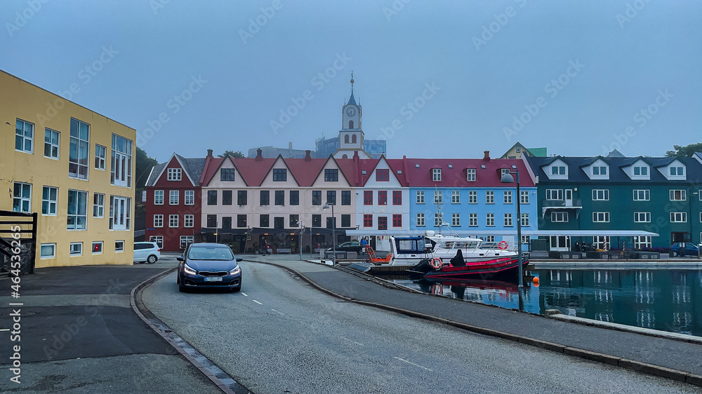 View of the beautiful city of Torshavan in the Faroe Islands and its clausal colorful houses, red building Goverment with grass on the roof , and marina.