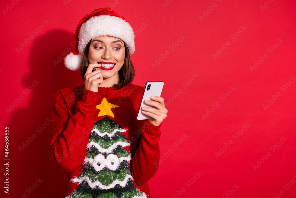 Photo of young excited girl look mobile nervous blogger post comment tradition xmas isolated over red color background Photo of young excited girl look mobile nervous blogger post comment tradition xmas isolated over red color background