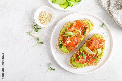Open sandwiches with salted salmon, guacamole avocado and microgreens. Seafood. Healthy food. Top view.