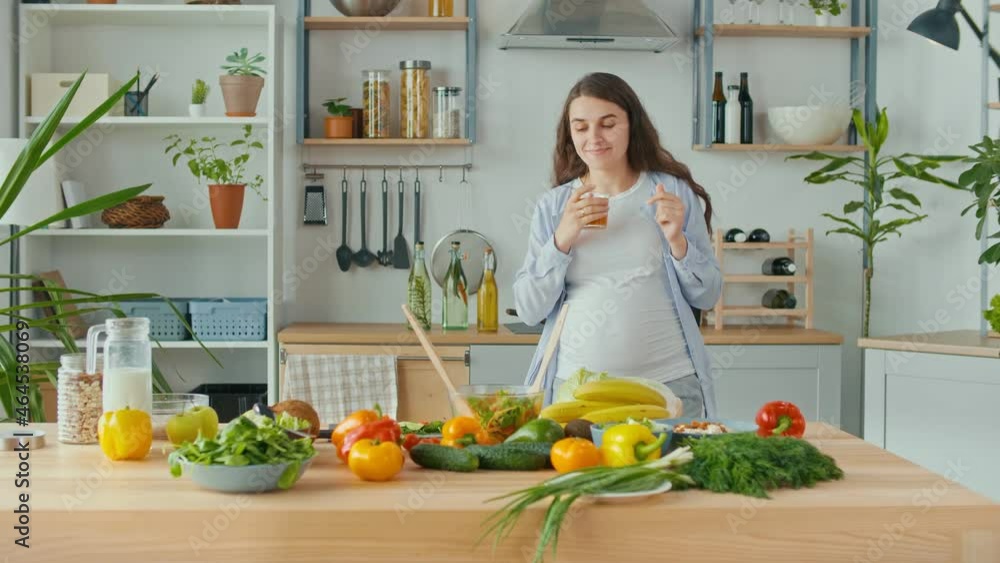 Happy Pregnant Woman Drinks Vegetable, Fruit Juice in the Kitchen. Portrait of a Carefree Cheerful Pregnant Woman While Making Breakfast. The Happiness of Motherhood. Healthy Food, Organic. Happy Pregnant Woman Drinks Vegetable, Fruit Juice in the Kitchen. Portrait of a Carefree Cheerful Pregnant Woman While Making Breakfast. The Happiness of Motherhood. Healthy Food, Organic.