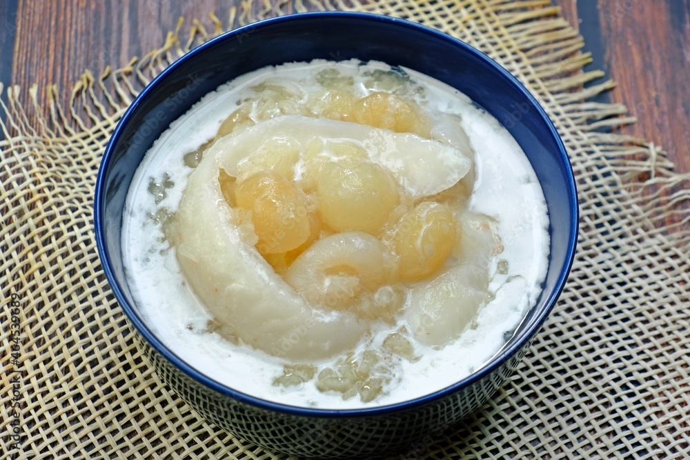 Sweet sticky rice with longan and coconut sliced in coconut milk (Kao niao piak lumyai). Authentic Thai dessert.