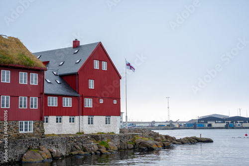 View of the beautiful Faroe Islands Flag in the city of Torshavan in the Governments red building with grass on the roof
