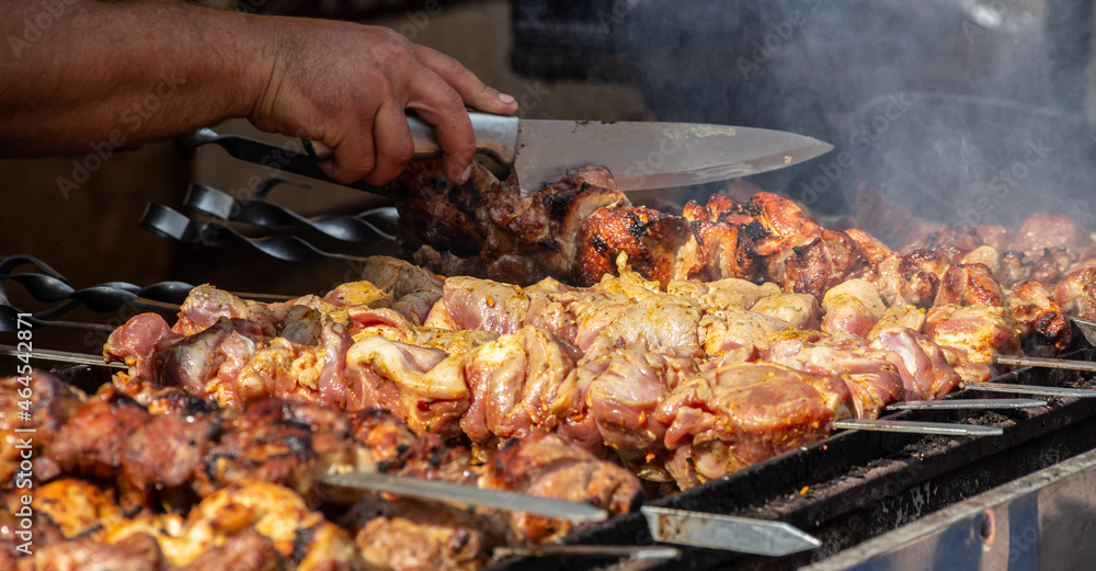 Marinated shashlik preparing on a barbecue grill over charcoal. Shashlik or Shish kebab popular in Eastern Europe. Shashlyk, skewered meat, was originally made of lamb. Roast Beef Kebabs On BBQ Grill