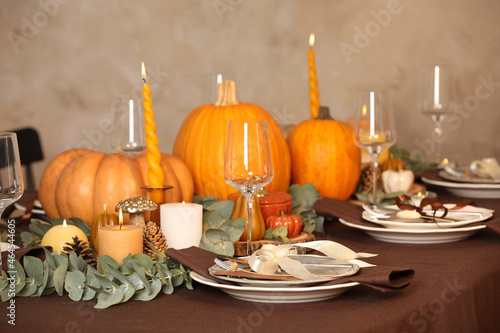 Beautiful autumn place setting and decor on table in room