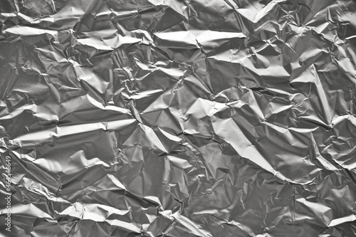 Close-up of crumpled silver aluminum foil texture. Abstract background for design.