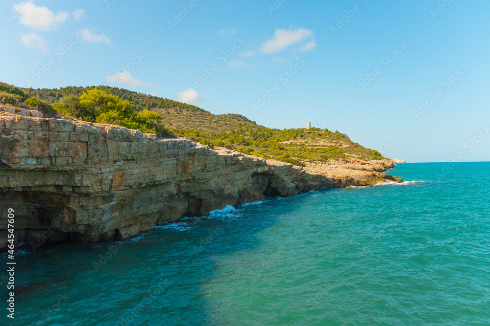 Rocky Coastal Mountain With Greenery And Historic Badum Tower In Peniscola, Spain