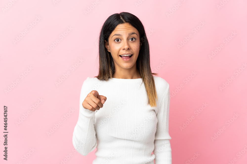 Caucasian girl isolated on pink background surprised and pointing front Caucasian girl isolated on pink background surprised and pointing front