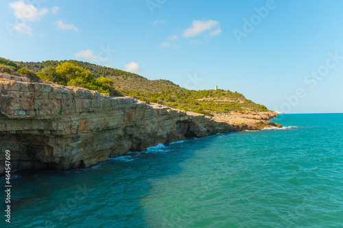 Rocky Coastal Mountain With Greenery And Historic Badum Tower In Peniscola, Spain photo