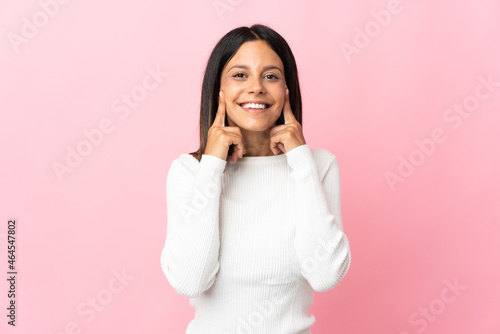 Caucasian girl isolated on pink background smiling with a happy and pleasant expression