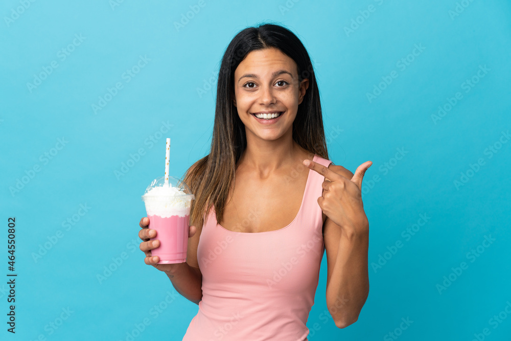 Young woman with strawberry milkshake giving a thumbs up gesture Young woman with strawberry milkshake giving a thumbs up gesture