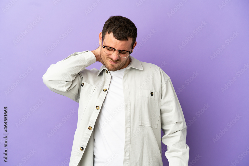 Brazilian man over isolated purple background with neckache Brazilian man over isolated purple background with neckache