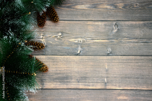 pine branches with cones on wooden background, place for text