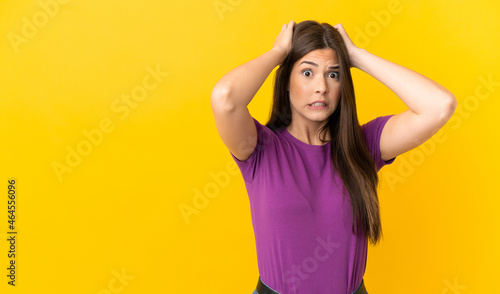 Teenager Brazilian girl over isolated yellow background doing nervous gesture © luismolinero