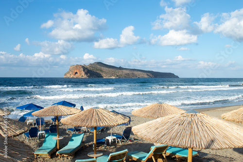 Crete, Agia Marina, Chania. Cretan beach scene at charming with parasols and sun beds on the beach.  Landscape aspect with copy space. photo