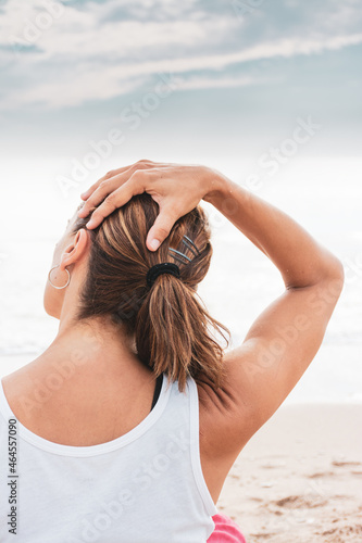 Woman doing neck stretches on the beach