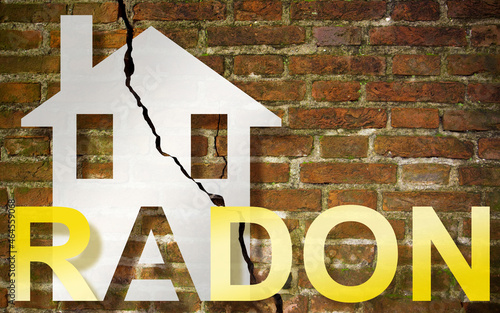 The danger of radon gas in our homes - concept with an outline of a small house with radon text against a damaged cracked brick wall - image with copy space photo