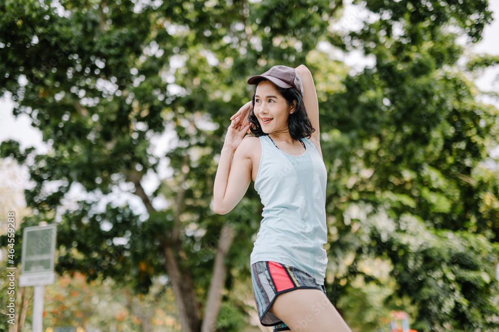 A beautiful woman stretching her body before running in the morning with a bright smile on her face. women's health care concept A beautiful woman stretching her body before running in the morning with a bright smile on her face. women's health care concept