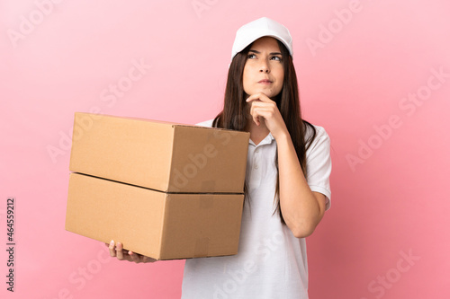 Delivery girl over isolated pink wall having doubts and thinking