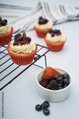cupcake with berries on a grid with blueberries, balckberries and strawberries