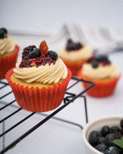 cupcake with berries on a grid with blueberries, balckberries and strawberries
