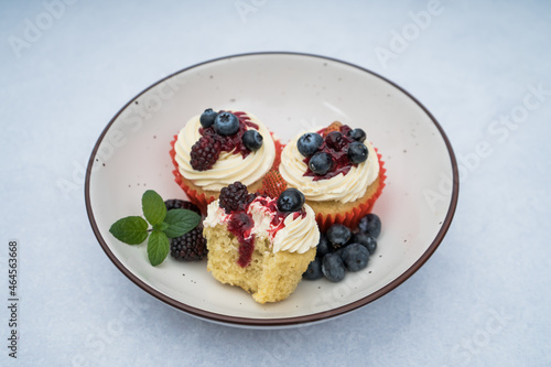 cupcake with berries on a plate on a marble background