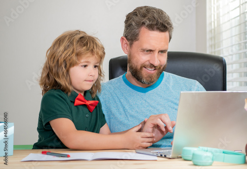 happy father and child son at school working online on laptop, e-learning
