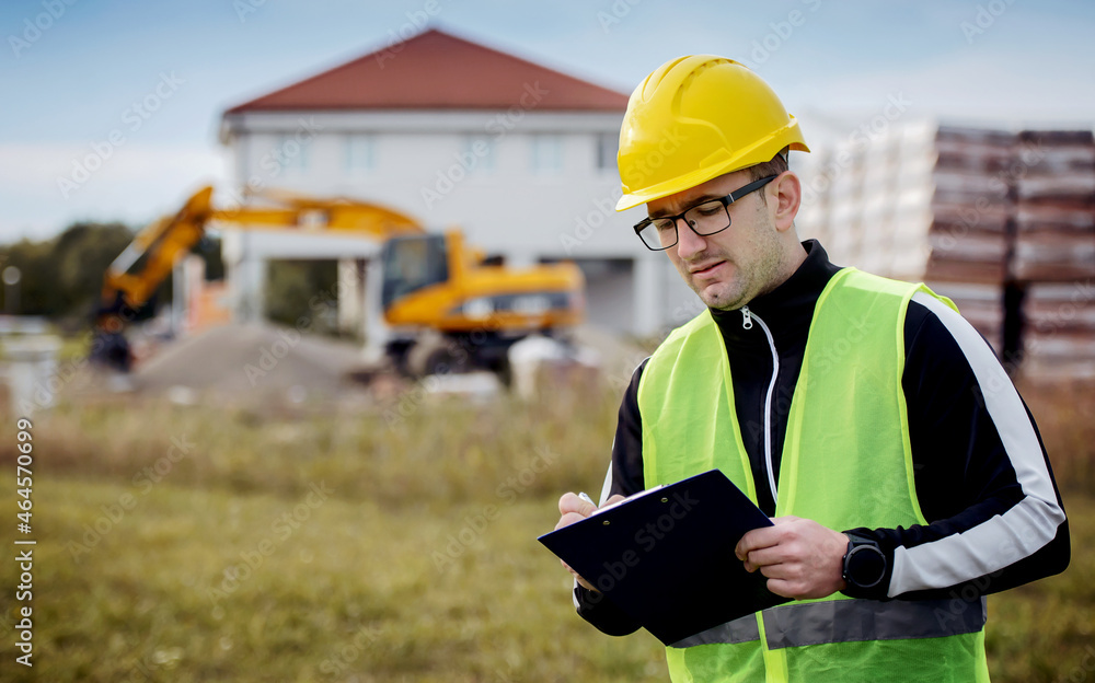 Fototapeta premium Technician making inspection on the construction site and taking a notes