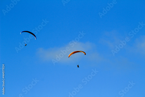 People paragliding on Santa Pola coast under blue sky