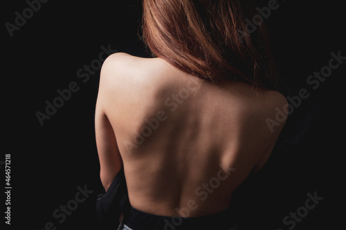 Young woman stands with bare back