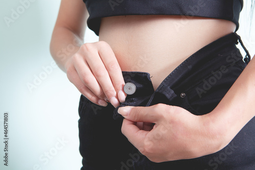 woman buttoning a button on jeans