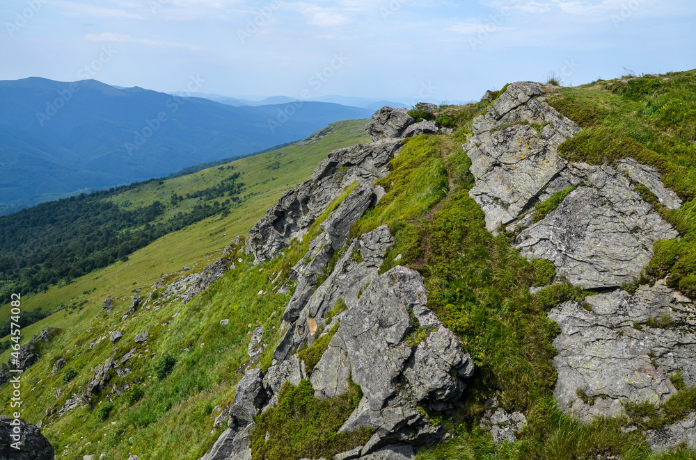 View from the rocks of Pikuj mount down the green valley ans forest in Ukrainian Carpathian Mountains on a summer day.