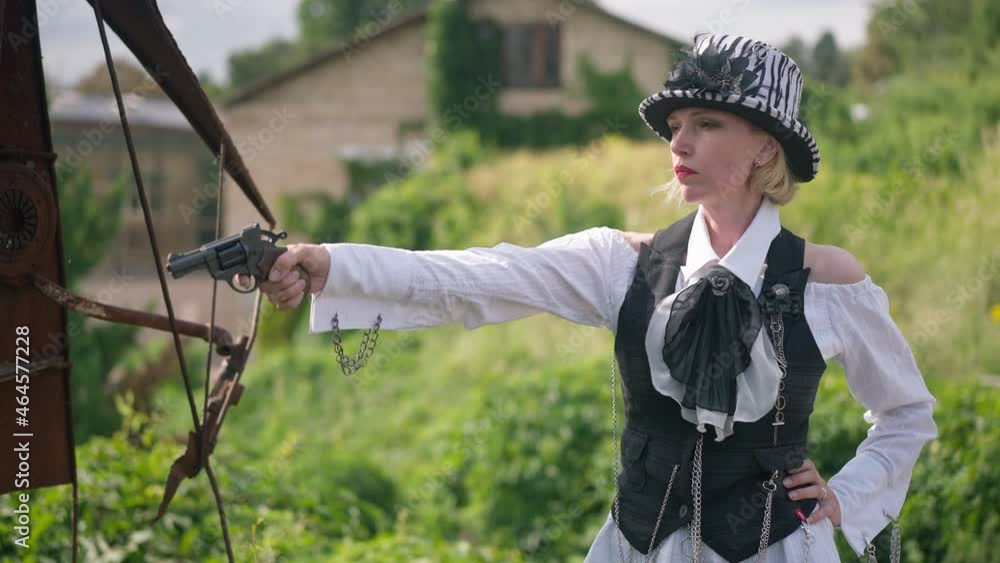 Confident gorgeous slim woman raising hand with gun aiming and shooting