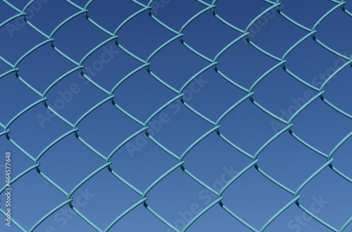 Against the background of a blue sky, a mesh metal mesh of blue color.