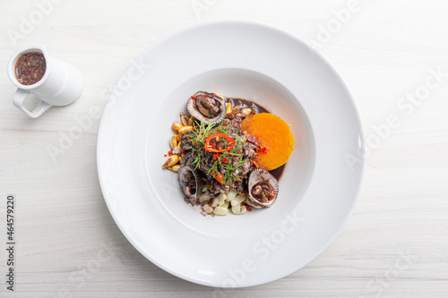 Black ceviche with shell, very typical in Peru. on white plate. 