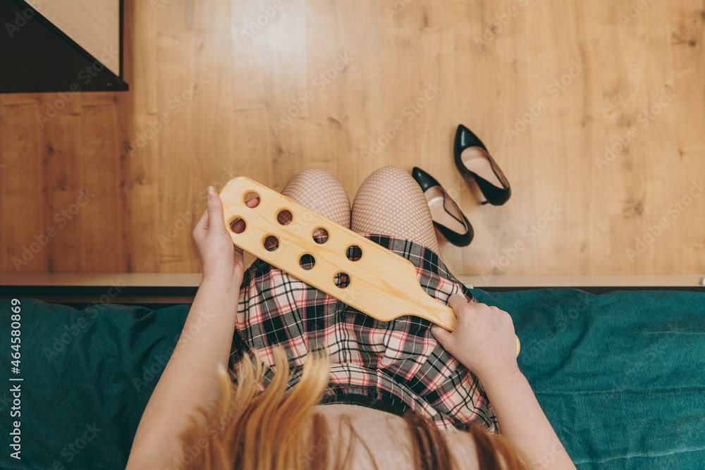 Schoolgirl with wooden paddle for spanking. Role play sexual games.  Corporal punishment concept. Stock Photo | Adobe Stock
