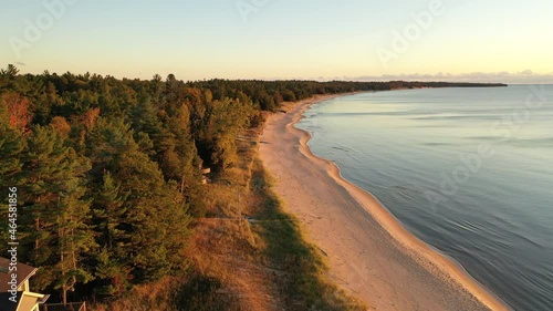 Aerial view of beachfront houses. Establishing shot of waterfront homes. Sunset sunrise sunlight,  Fall Autumn colorful trees. Midwest USA, Door county Wisconsin, lake Michigan.