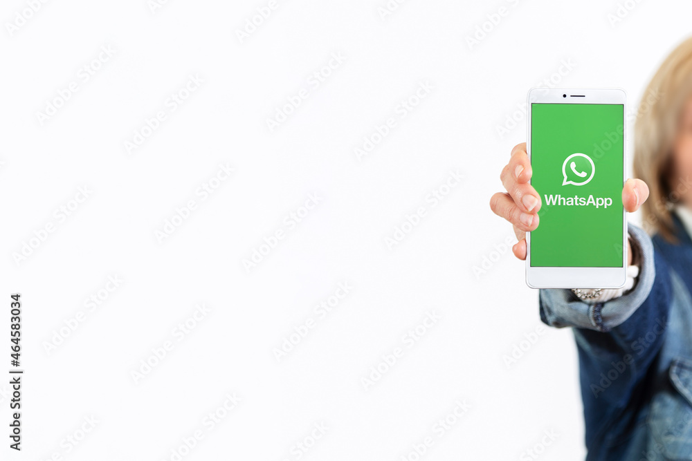 A hand of woman over white background showing a smartphone with whatsapp  logo on the screen. ROSARIO, ARGENTINA - OCTOBER 22, 2021 Stock Photo |  Adobe Stock