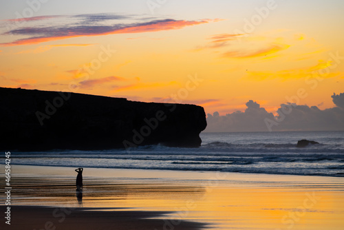 Warming up after an evening surfing. Amoreira Beach near Aljezur in the Algarve, Portugal.