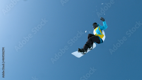 BOTTOM UP: Male snowboarder does a spectacular grab trick high in the air.