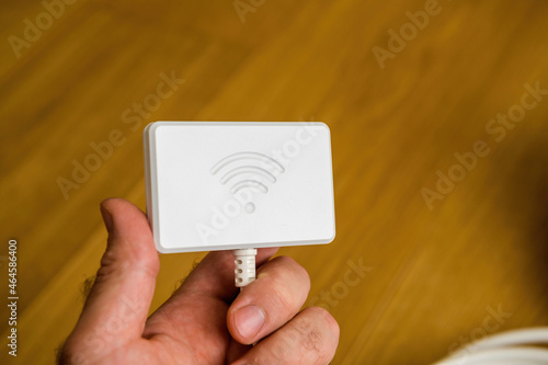 male hand holding new Wifi dongle for modern refrigerators - control with app and smartphone photo