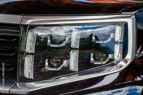 Headlight lamp of new car. Close up detail on one of the LED headlights modern car. Exterior closeup detail. Closeup headlights of car..