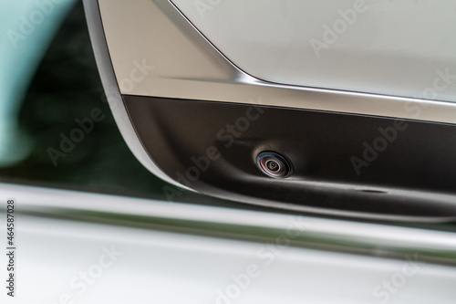 Close up view of surround view camera system on modern car side rear mirror. Blind spot and parking assistant camera. © Roman