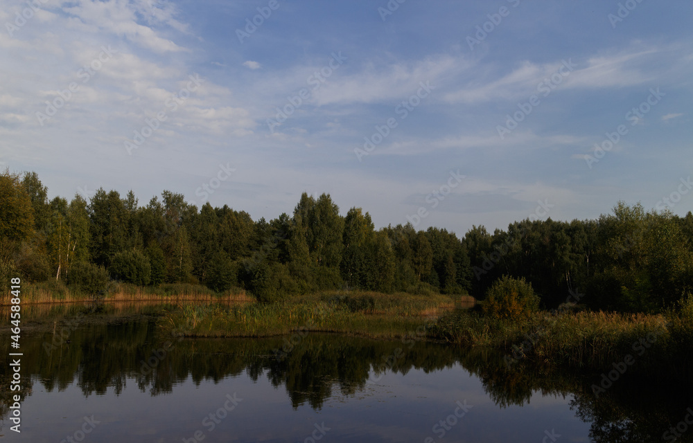 Lake in Moscow oblast, central Russia. Blue sky with curly clouds