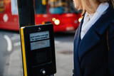 Beautiful woman in the push button and wait for signal opposite crossroad in London, British capital with double decker bus in the background