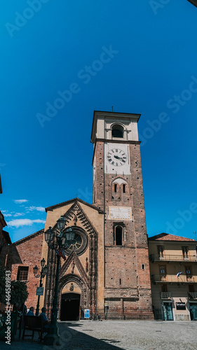 Vertical shot of the medieval cathedral external view against a blue sky in Chivasso, Italy