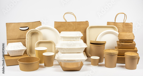 Group shot of biodegradable and recyclable food packaging on white background, paper plates, containers, bags
